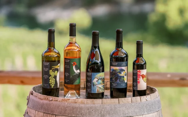Lineup of Alamitos wine bottles on a barrel