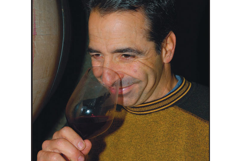 Alamitos Vineyards head winemaker George Troquato inhaling the scent of wine from a glass