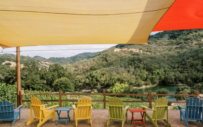 Adirondack chairs and side tables facing the Almaden Reservoir