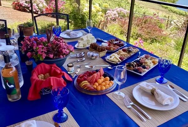 Beautifully set and laid table on the patio of Alamitos Vineyards with flowers and charcuterie boards