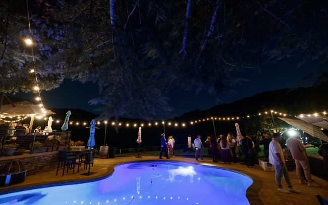 Evening event at Alamitos Vineyards with people milling around the pool